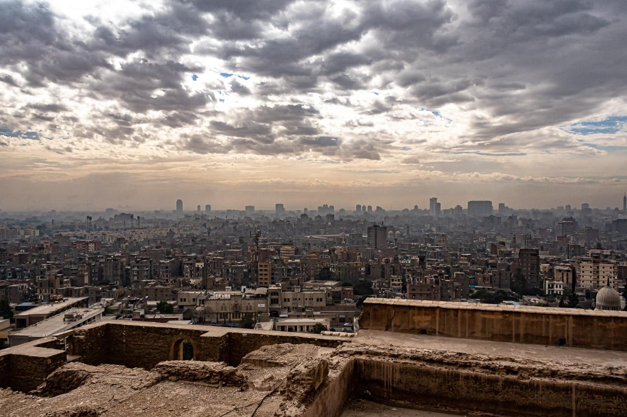 Mirage Urbain est une œuvre photographique capturant la majestueuse vue du Caire depuis la mosquée Mohammed Ali. Cette image, mélangeant harmonieusement les tons sable et les éléments architecturaux.