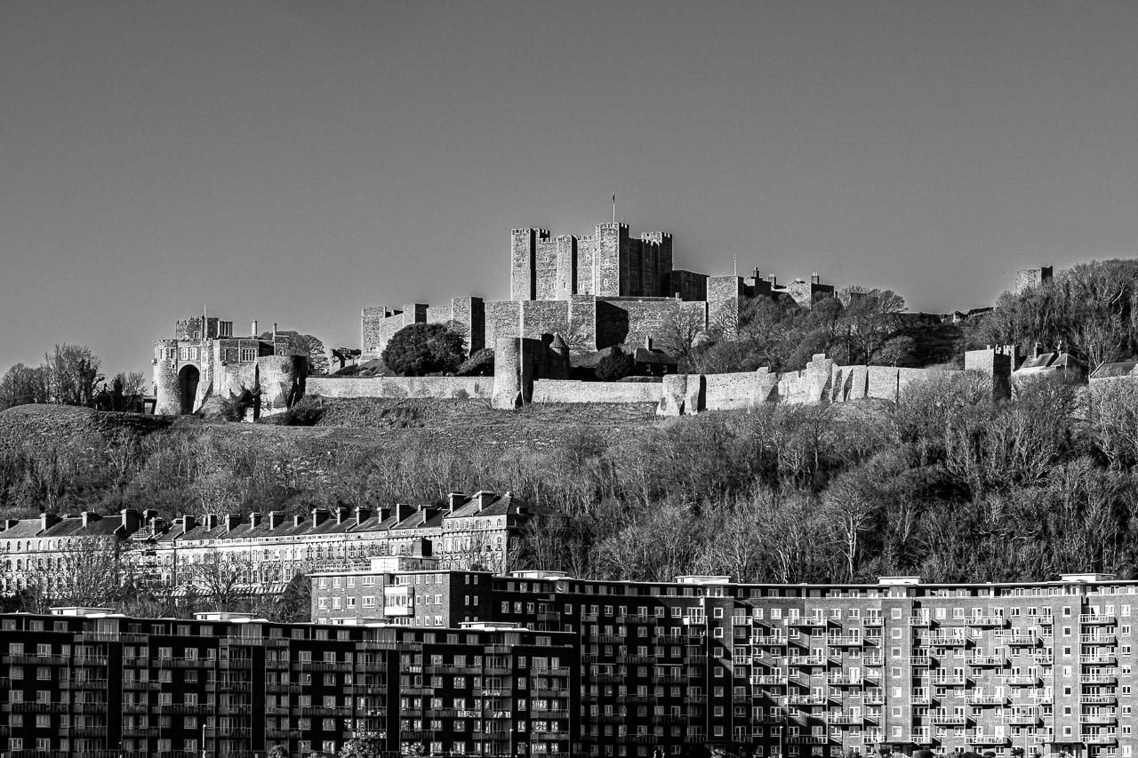 Dans Face à Face, découvrez le contraste saisissant entre l'ancien château de Douvres, témoin de siècles d'histoire, et les immeubles modernes qui s'élèvent à ses pieds.