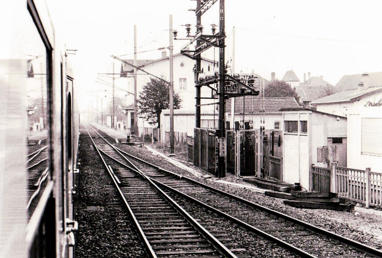 Découvrez 'Chemin d'écolier', une capture émotive en noir et blanc d'une gare enveloppée de brouillard lors d'un voyage solitaire.