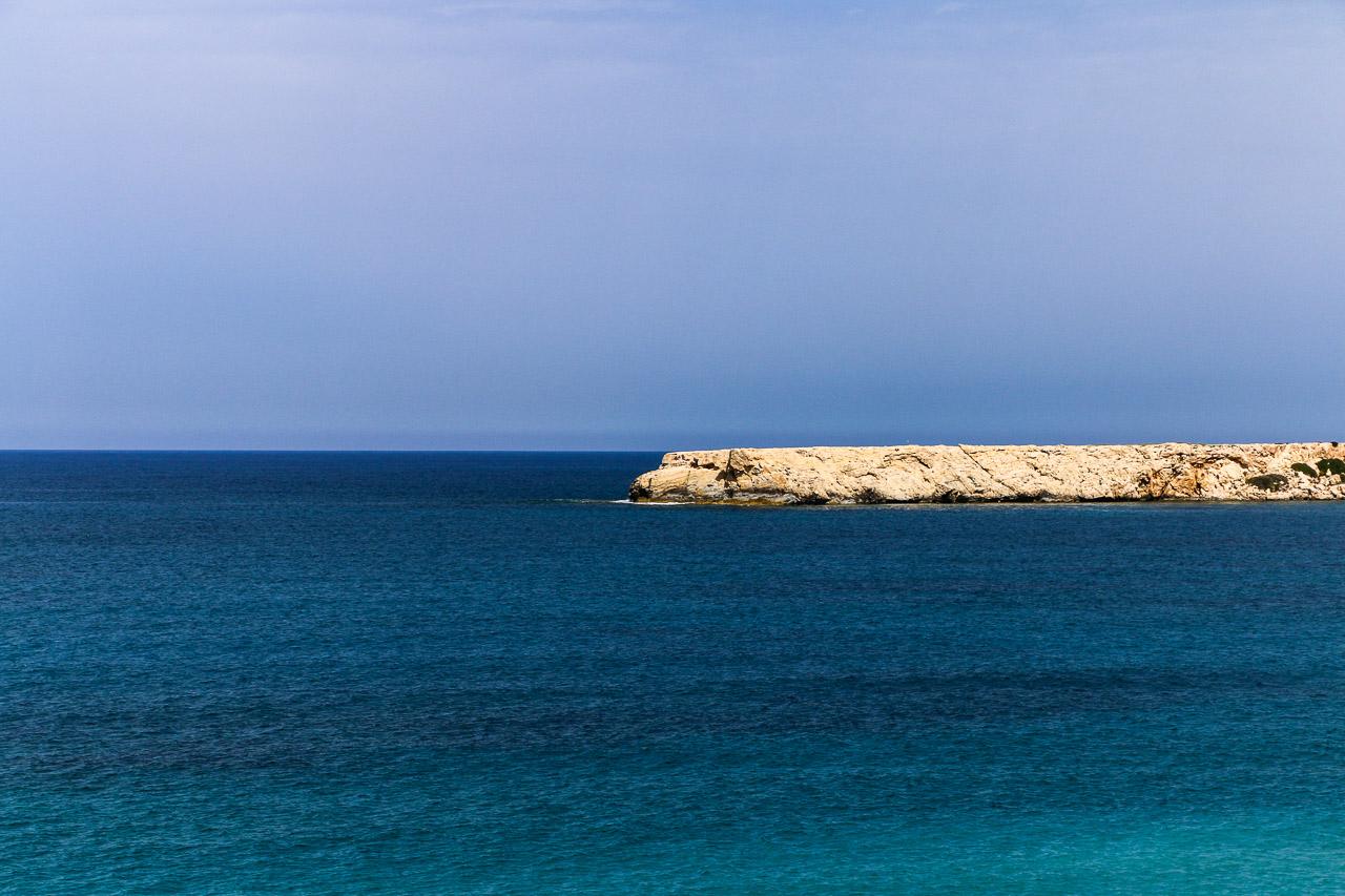 Explorez Azur Fractionné, une œuvre de la série Keshiki qui illustre une jetée naturelle s'étendant dans une mer bleue sous un ciel sans nuages à Chypre.