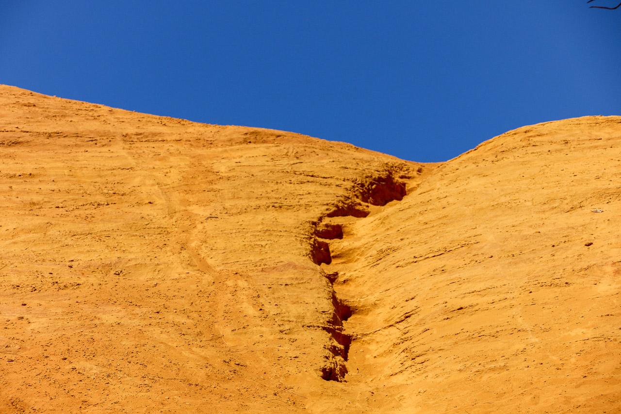 Escalier vers l’Interdit : une photo captivante du Colorado Provençal, où un escalier ocre mène à un ciel bleu éclatant. Invitation à l'évasion !